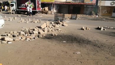 protesters in sudan setting up barricades along a street in Khartoum